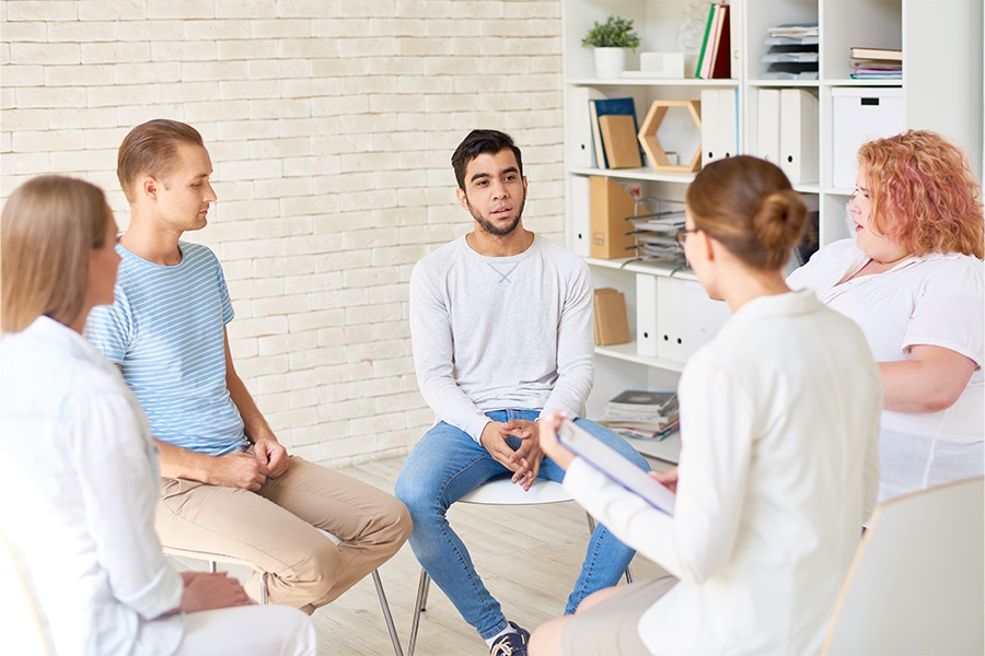 group of people sitting in a circle during a mental health group therapy session